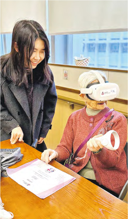 學生義工會在院舍教長者使用虛擬實境（VR）系統，並調節影片速度、協助操作手掣，也會引導長者投入感受場景，及監察他們會否不適應。完成體驗後，學生會與長者聊天，討論感受和生活往事。（東華學院提供）