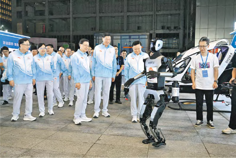 特首李家超（前排左一）上月在深圳出席十五運倒計時100天儀式時，觀摩優必選機械人展示。（政府新聞處）
