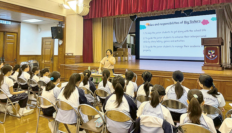 圖為註冊教育心理學家江翠欣（站立者）入校進行「大姐姐培訓計劃」，培訓高年級學生擔任「大姐姐」，協助新生適應。