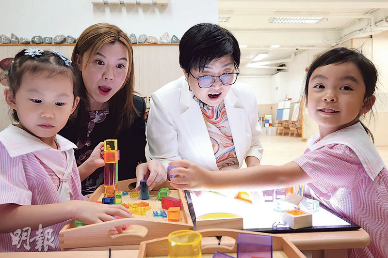 啟思幼稚園校監劉肇薇（左二）及馬鞍山分校校長蘇慧玲（右二）與學生嬉戲互動。啟思幼稚園馬鞍山分校設多個遊戲角落，讓幼兒發揮創意。（李紹昌攝）