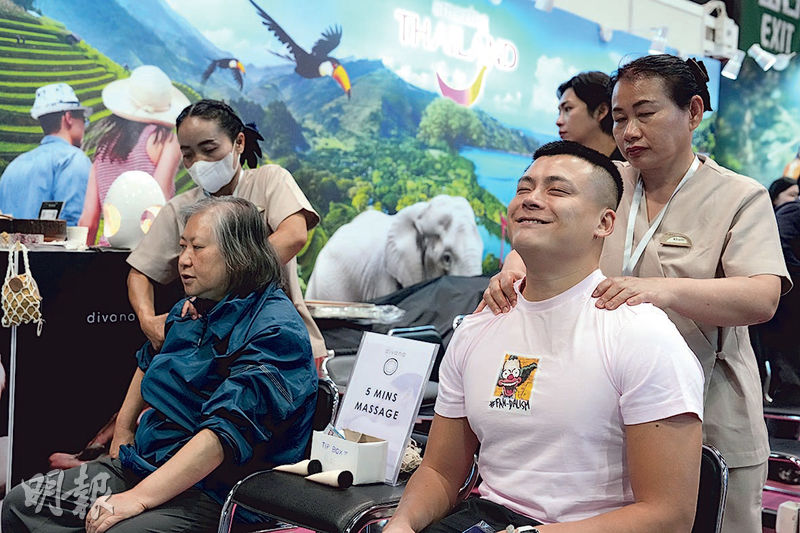 泰國政府旅遊局（香港）於旅遊博覽會提供即場5分鐘按摩體驗，有男士嘗試泰國師傅手藝時面露笑容。（廖凱霖攝）