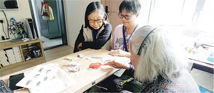 計劃義工會定期上門探訪認知障礙患者,並做健腦訓練;義工惠蓮(左)家訪時曾用教材與年長患者玩遊戲。(救世軍大埔長者社區服務中心提供)