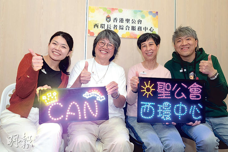 聖公會西環長者綜合服務中心前年成立K-pop舞團CAN，不時獲邀表演，中心更訂製應援燈牌為團員打氣。左起中心教育及發展服務單位主任劉子鉫、團員Shirley及貝貝、助理程序幹事陳志堅。（徐君浩攝）