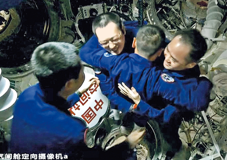 神舟23號乘組指令長朱楊柱（背對擁抱兩人者）率先進入太空站節點艙，對在軌的神21乘組說：「7個月沒見，非常想念。」（央視截圖）