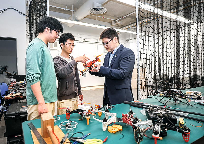 助理教授段鵬浩（右一）指導學生進行 無人機的研發與測試，鼓勵學生發展科 研興趣，抓緊低空經濟的發展機遇。