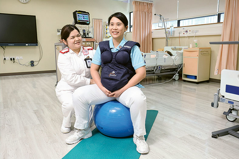 Eva（藍衣者）穿上上妊娠模擬器，身感受孕婦的身體負擔，培養同理心。