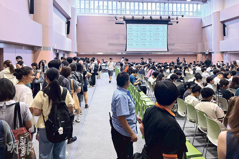 樹仁大學禮堂昨坐滿輪候即場筆試的學生及家長,當中繳付報名費的隊伍排起長龍。(吳卓瑩攝)
