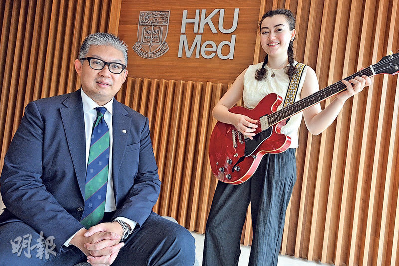 港大醫學院內外全科醫學士課程六年級學生葛倩恩(右)說,她4歲起學習小提琴,11歲起登台演出,近年開始學結他及寫歌,學習樂器令她雙手協調,也可在高壓環境下保持專注,有助提升手術技能。左為港大醫學院助理院長(教學法及評核)許長峯。(曾憲宗攝)