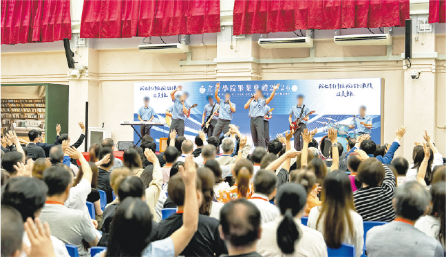 懲教署昨日在白沙灣懲教所舉行「立德學院」畢業禮，由在囚者樂隊表演以答謝懲教人員、導師及家人的支持，台下不少觀眾跟着樂隊成員揮手。（政府新聞處）